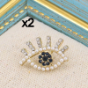 Lot x2 pin's oeil protecteur en métal, strass et perles blanches acrylique 0623514 doré